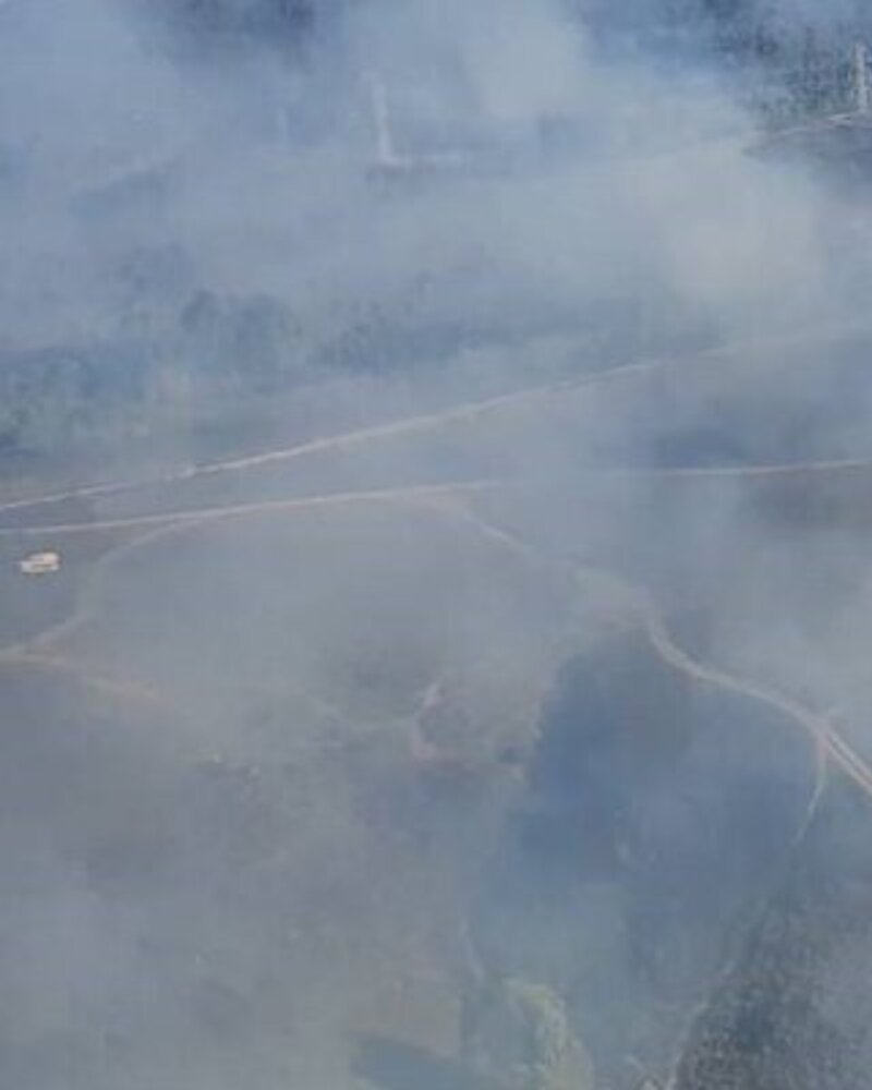 Vista aérea de um incêndio florestal com fumo a cobrir a paisagem.