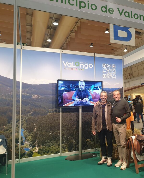 Stand do Município de Valongo com pessoas, tela e manequim de escalada.