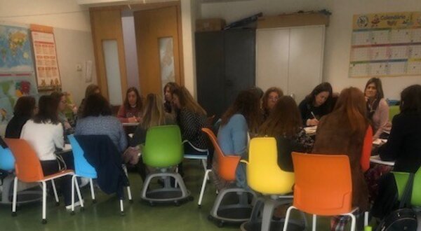 Mesa com livros sobre voluntariado e grupo de pessoas a discutir.