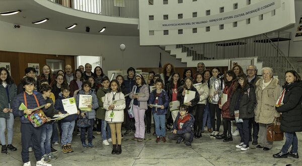 Grupo de pessoas, incluindo crianças, posando na biblioteca de Valongo.
