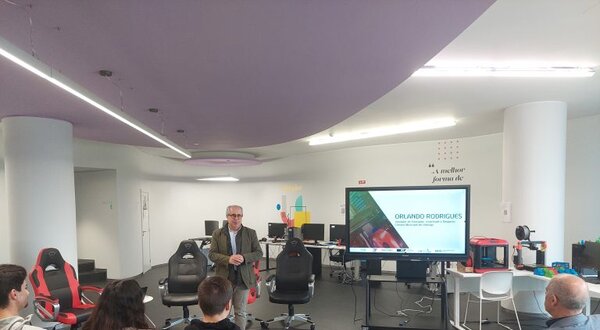 Um orador apresenta-se a um grupo de pessoas em uma sala moderna.