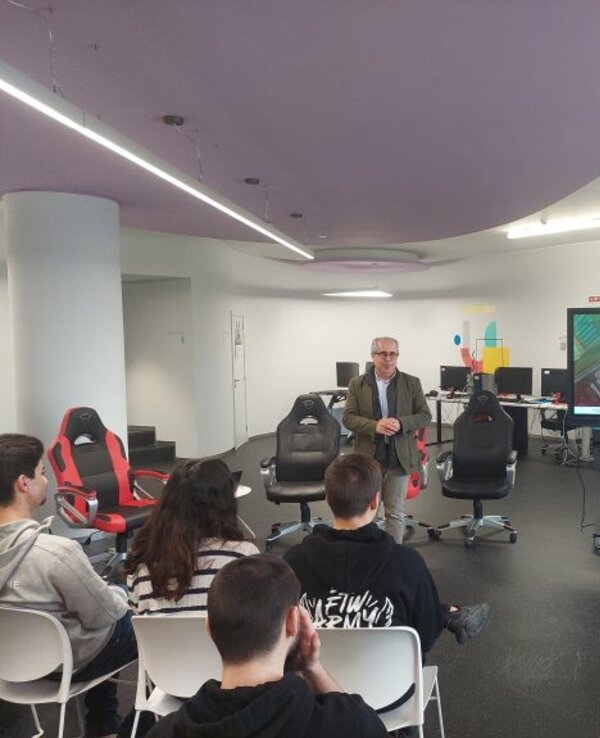 Um orador apresenta-se a um grupo de pessoas em uma sala moderna.