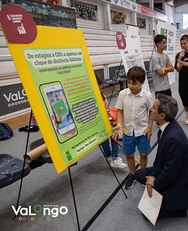 Um grupo de pessoas observa um cartaz sobre tecnologia assistiva.