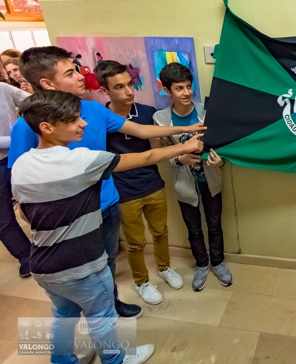 Grupo de pessoas segurando uma bandeira do Concelho de Valongo.