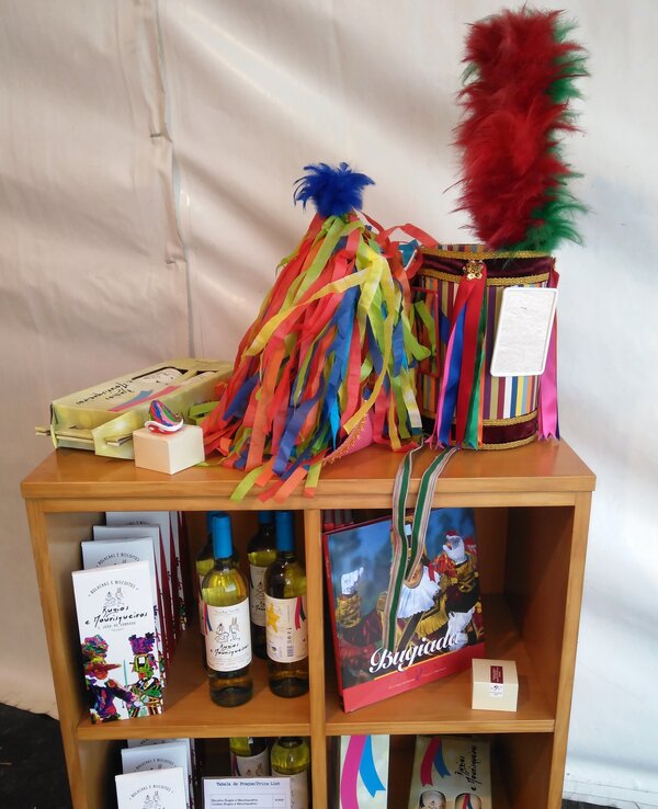 Exposição de produtos regionais com garrafas de vinho e adereços coloridos.