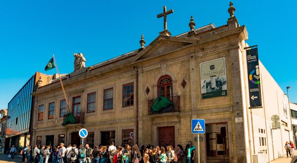 Grupo de pessoas em fila à frente de um edifício histórico em Valongo.