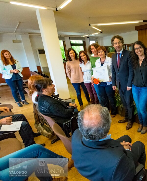 Grupo de pessoas a receber um prémio em cerimónia oficial.