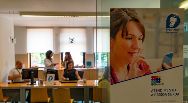 Cartaz informativo sobre atendimento a pessoas surdas em espaço público.