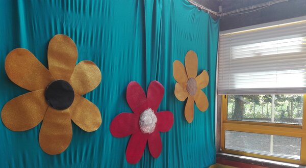 Paredes decoradas com flores grandes e coloridas, ao lado de uma piscina de bolas.