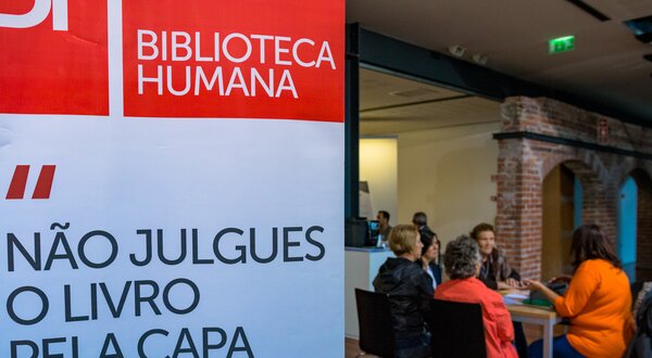 Painel da Biblioteca Humana com a frase 'Não julges o livro pela capa'.