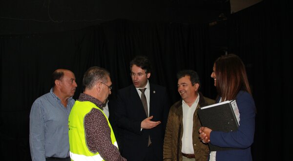 Grupo de pessoas em conversa, algumas com coletes de segurança e pastas.