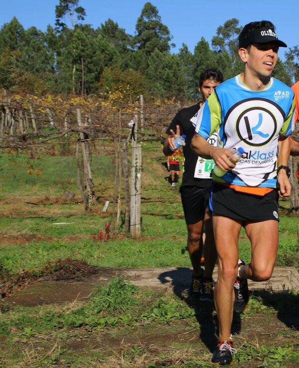 Três corredores em um percurso ao ar livre, rodeados por vinhedos.