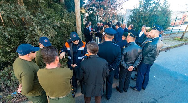 Grupo de profissionais em uniforme a discutir em ambiente exterior.