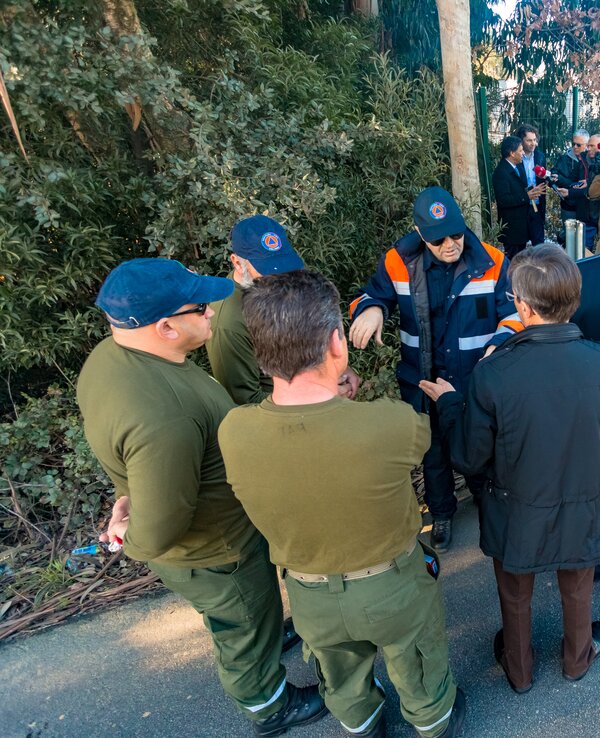 Grupo de profissionais em uniforme a discutir em ambiente exterior.