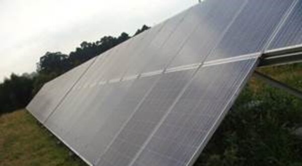 Painéis solares dispostos em um campo, captando luz solar.