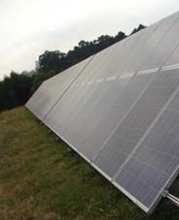 Painéis solares dispostos em um campo, captando luz solar.