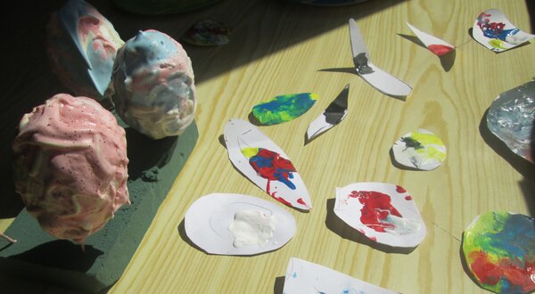 Vários objetos coloridos feitos à mão, incluindo ovos e recortes de papel.