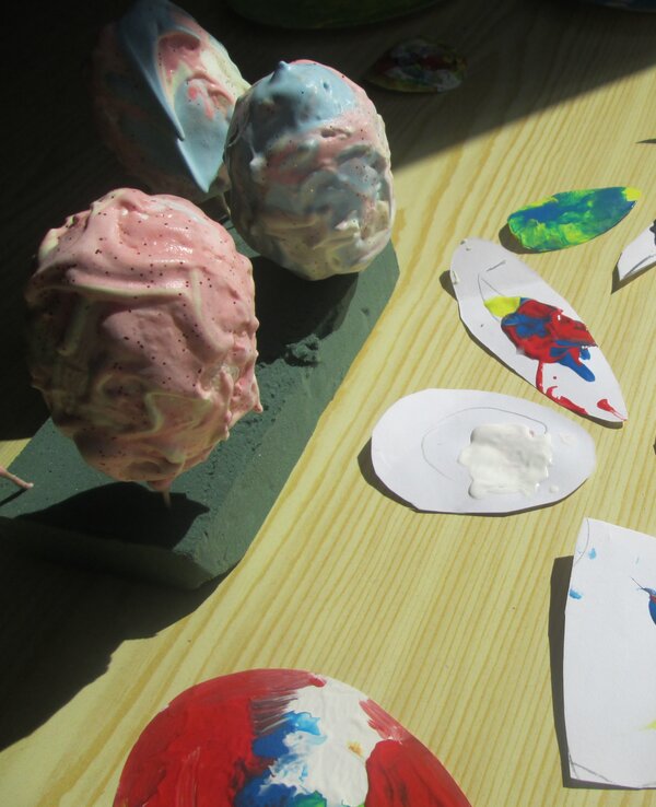 Vários objetos coloridos feitos à mão, incluindo ovos e recortes de papel.