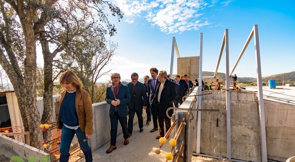 Grupo de pessoas a caminhar num local de construção ao ar livre.