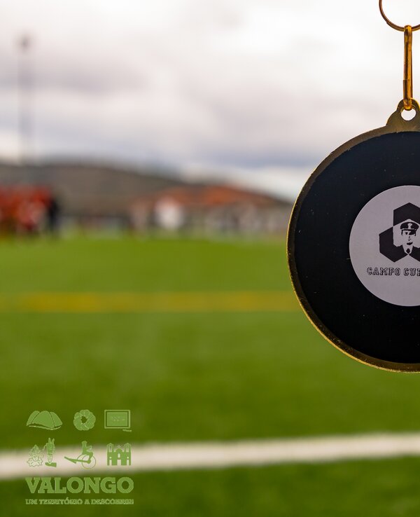 Medalha dourada com o logótipo do 'Campus Cup 2018' em fundo desfocado.