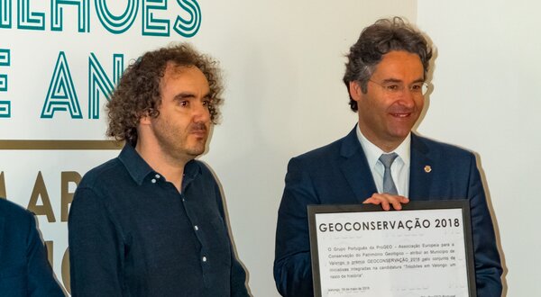 Duas pessoas a receber um prémio de Geoconservação 2018, com um diploma.