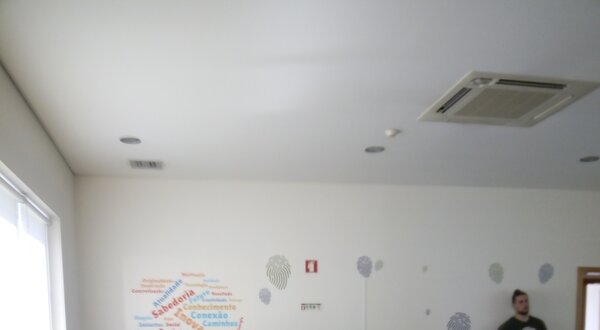 Grupo de pessoas em sala de aula, com computadores e um orador à frente.