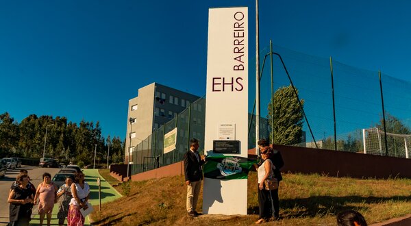 Inauguração da escola EHS Barreiro, com pessoas a assistir e um painel a ser descoberto.