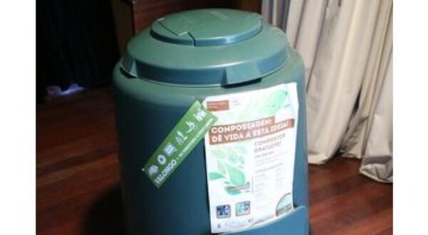 Composteira verde com materiais orgânicos e um recipiente de terra.